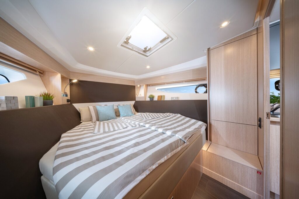 Motoryacht chartern in Neustadt in Holstein: Die helle Eignerkabine mit großem Doppelbett und Deckenluke an Bord der BAVARIA SR38 von Hanse Yachtcharter.