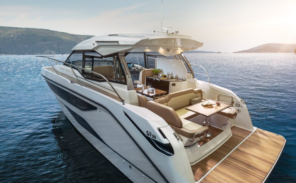 Motoryacht chartern in Neustadt in Holstein: Der einladende, moderne Salon mit gemütlicher Sitzecke unter Deck der BAVARIA SR38 bei Hanse Yachtcharter.